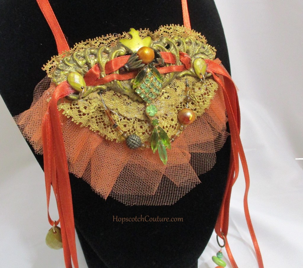 Close up of Orange and Gold Victorian Style Bib Necklace, Statement Necklace by Marelle Couture for Hopscotch Couture https://hopscotchcouture.com/products/victorian-satin-choker-antique-upcycle-lace-necklace-antique-brass-necklace-ooak?_pos=2&_psq=orange&_ss=e&_v=1.0 #statementnecklace #orangenecklace #bibnecklace