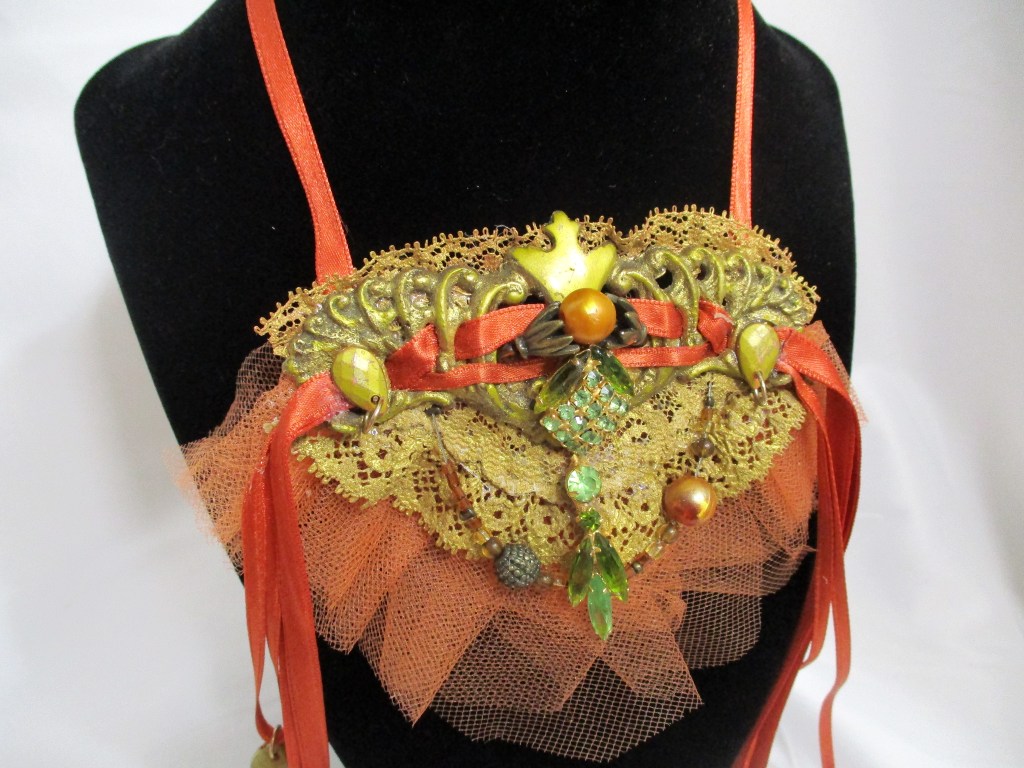 Up close top of Orange and Gold Victorian Style Bib Necklace, Statement Necklace by Marelle Couture for Hopscotch Couture https://hopscotchcouture.com/products/victorian-satin-choker-antique-upcycle-lace-necklace-antique-brass-necklace-ooak?_pos=2&_psq=orange&_ss=e&_v=1.0 #statementnecklace #orangenecklace #bibnecklace